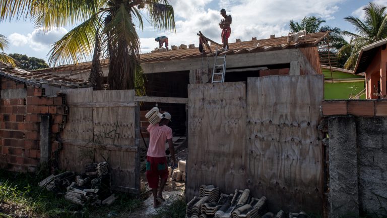 On July 9th, 2020 local residents work on building a house in the Bananal neighborhood, in the city of Maricá, state of Rio de Janeiro, Brazil. After the implementation of Mumbuca, residents who benefit from digital currency now have the chance to build or renovate their own housing. Photography by Leonardo Carrato for Rest of World.