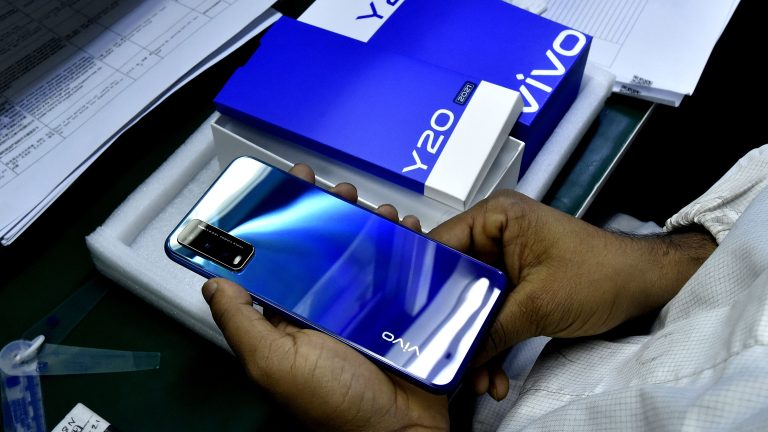 A worker packs a Vivo cellphone on an assembly line.