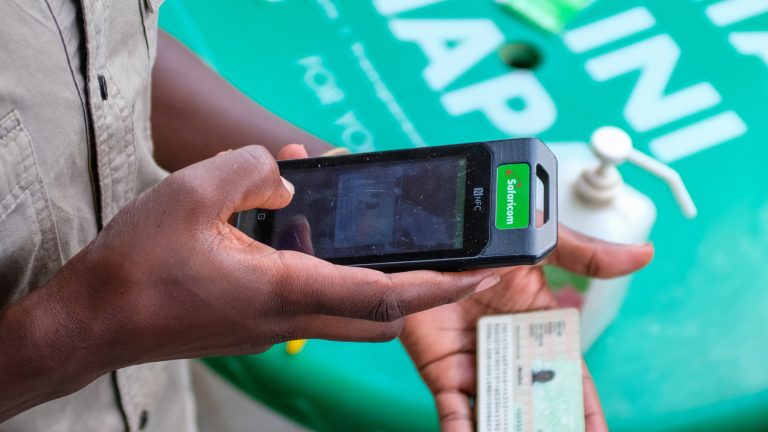 A customer care specialist helps out with services during the new Sim Card registration outside Safaricom (one of the leading mobile telephone network providers in Kenya) customer care shop.