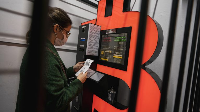 A woman uses a Bitcoin ATM machine.
