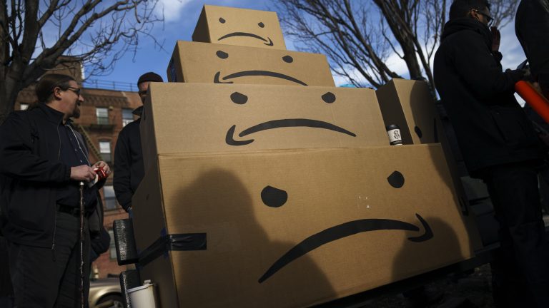 Boxes with the Amazon logo turned into a frown face are stacked up after a protest against Amazon.