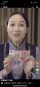 A screenshot from the Chinese miniseries Deflation Made Me a Tycoon showing a woman holding up a 100 Renminbi banknote.