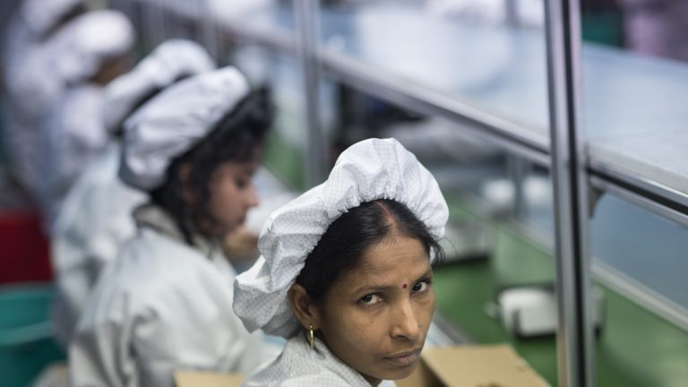 This is a photo of a female factory worker in India seated at her work station.