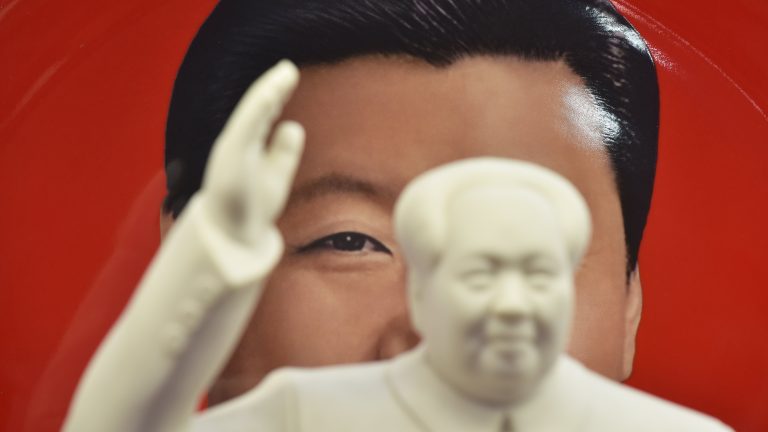 A photo showing a an image of Chinese President Xi Jinping behind a statue of late communist leader Mao Zedong.