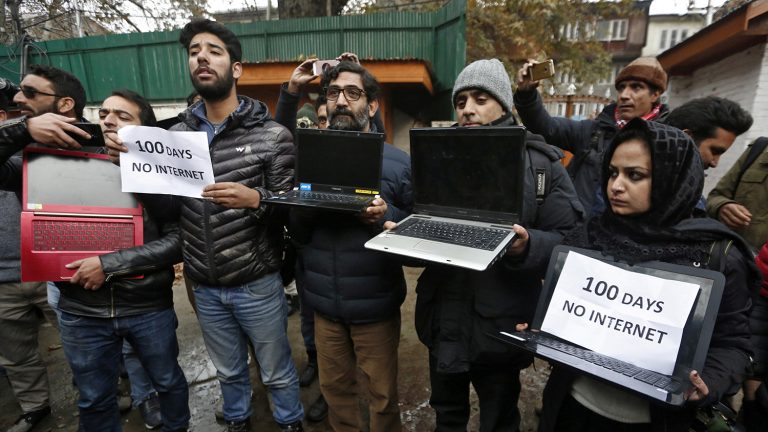 A photograph showing a protest with people displaying laptops and placards with the text '100 days No internet'.